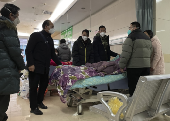 A man pulls a cloth to cover up the face of an elderly woman whose vitals flatlined as emotional relatives gather silently around her for a final farewell before her body is taken away at the emergency department of the Langfang No. 4 People's Hospital in Bazhou city in northern China's Hebei province on Thursday, December 22, 2022. (AP Photo)