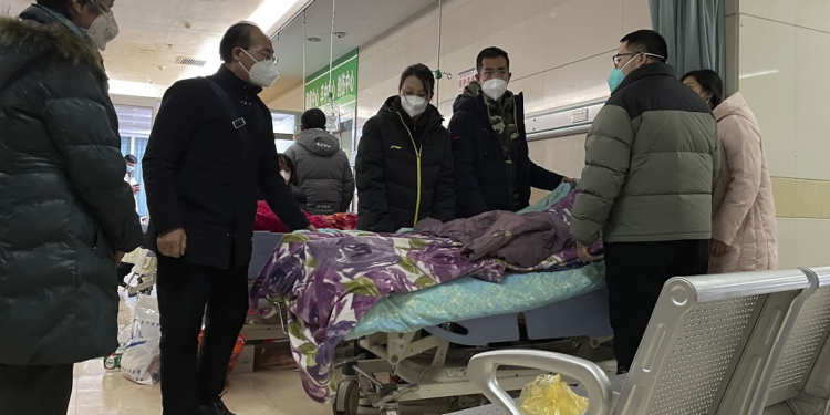 A man pulls a cloth to cover up the face of an elderly woman whose vitals flatlined as emotional relatives gather silently around her for a final farewell before her body is taken away at the emergency department of the Langfang No. 4 People's Hospital in Bazhou city in northern China's Hebei province on Thursday, December 22, 2022. (AP Photo)