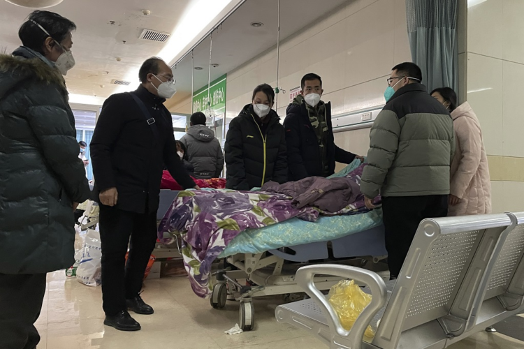 A man pulls a cloth to cover up the face of an elderly woman whose vitals flatlined as emotional relatives gather silently around her for a final farewell before her body is taken away at the emergency department of the Langfang No. 4 People's Hospital in Bazhou city in northern China's Hebei province on Thursday, December 22, 2022. (AP Photo)
