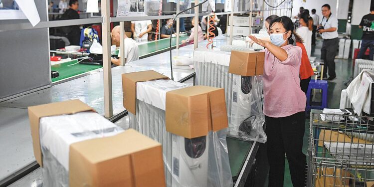 Workers pack heaters at a manufacturer in Ningbo, Zhejiang province, Sept 27, 2022. [WANG GANG/CHINA NEWS SERVICE]