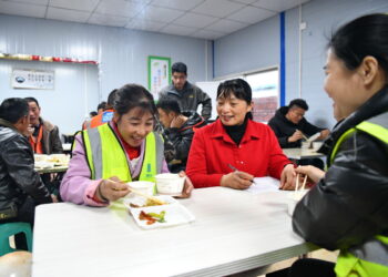 A deputy to the National People's Congress talks to female workers to alert them to new regulations designed to protect them and their legitimate rights. ZHU HAIPENG/FOR CHINA DAILY