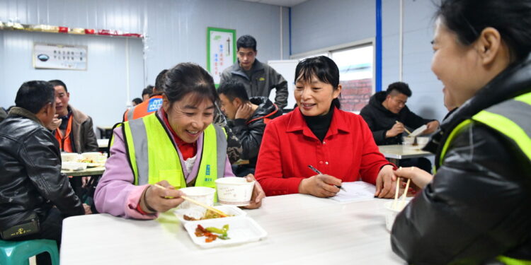 A deputy to the National People's Congress talks to female workers to alert them to new regulations designed to protect them and their legitimate rights. ZHU HAIPENG/FOR CHINA DAILY