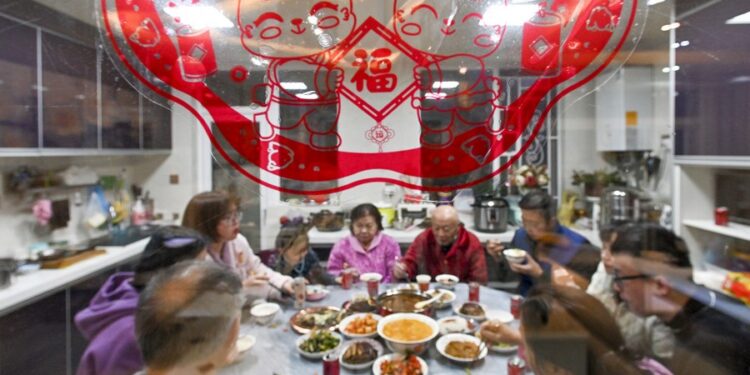 A family gathers to have dinner together on Lunar New Year's Eve in southwest China's Guizhou Province, Jan. 21, 2023. (Photo by Li Hua/Xinhua)