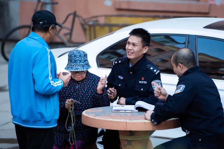 File photo shows a policeman talking with residents at a community in Harbin, northeast China's Heilongjiang Province (XINHUA)