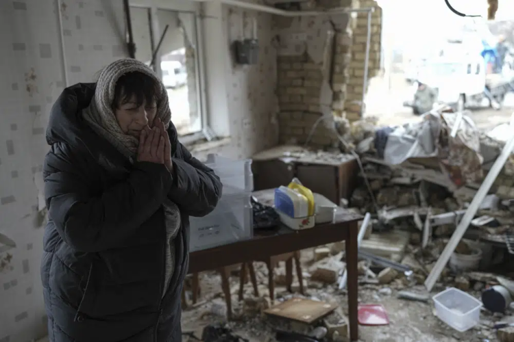 Halina Panasian, 69, reacts inside her destroyed house after a Russian rocket attack in Hlevakha, Kyiv region, Ukraine, Thursday, Jan. 26, 2023. (AP Photo/Roman Hrytsyna)