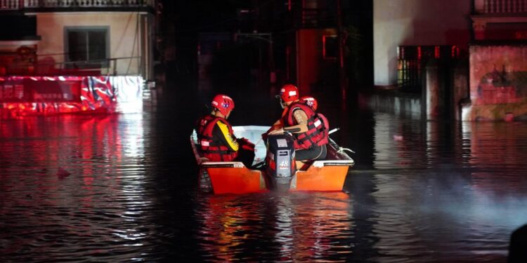 Rescuers enter a village to evacuate stranded people in flood water in Dexing, East China's Jiangxi province, June 20, 2022. [Photo/Xinhua]