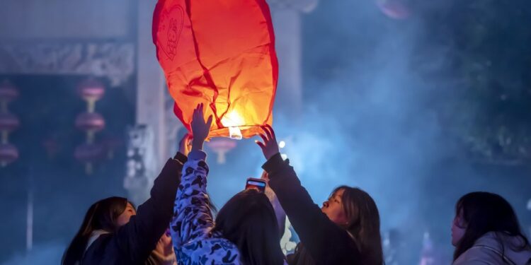 People release a sky lantern to make a wish for good fortune at a park in Qianxi, southwest China's Guizhou Province, on January 1 (XINHUA)