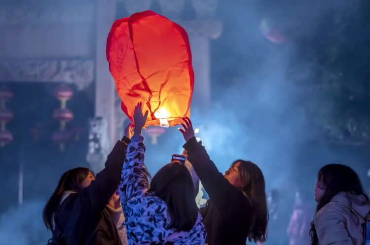 People release a sky lantern to make a wish for good fortune at a park in Qianxi, southwest China's Guizhou Province, on January 1 (XINHUA)