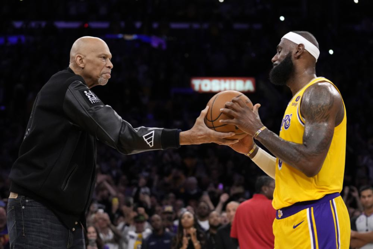 Kareem Abdul-Jabbar, left, hands the ball to Los Angeles Lakers forward LeBron James after passing Abdul-Jabbar to become the NBA's all-time leading scorer during the second half of an NBA basketball game against the Oklahoma City Thunder Tuesday, Feb. 7, 2023, in Los Angeles. (AP Photo/Ashley Landis)