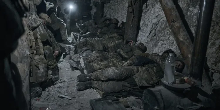 Soldiers of the Ukrainian 3rd Army Assault Brigade of the Special Operations Forces (SSO) "Azov" rest in a blindage after night fight near Bakhmut, Donetsk region, Ukraine, Saturday, Feb. 11, 2023. (AP Photo/Libkos)