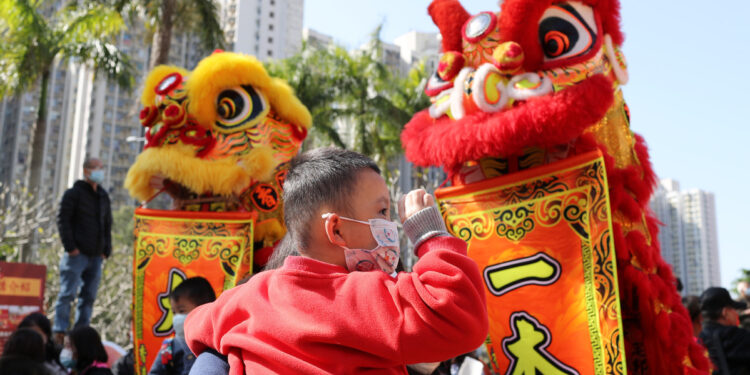 People watch lion dances at a square in Hong Kong, Jan 28, 2023. [Photo/Xinhua]
