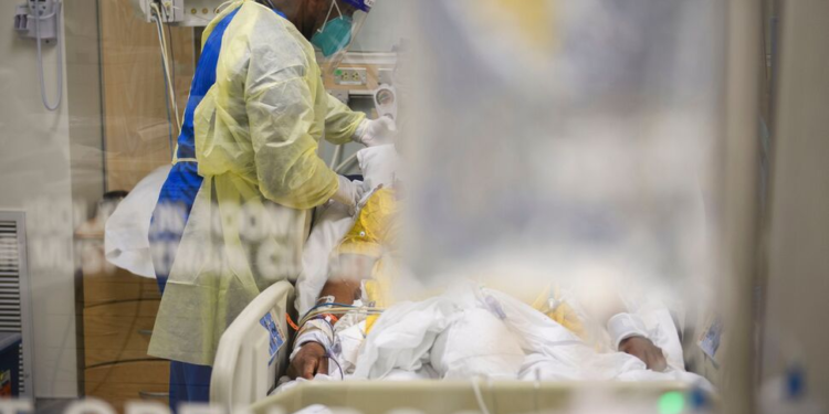 A nurse in personal protective equipment (PPE) cares for a patient in a Covid-19 intensive care unit on January 6, 2021, in Los Angeles, California.(PATRICK T. FALLON/AFP VIA GETTY IMAGES)