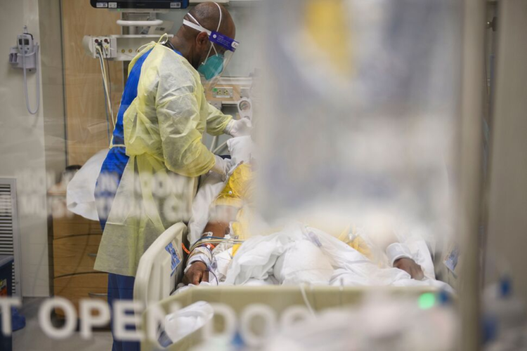 A nurse in personal protective equipment (PPE) cares for a patient in a Covid-19 intensive care unit on January 6, 2021, in Los Angeles, California.(PATRICK T. FALLON/AFP VIA GETTY IMAGES)