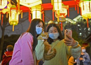 Tourists pose for photos with lanterns during a Lantern Festival fair held in the Nantou ancient town in Shenzhen, south China's Guangdong Province, on Feb. 4, 2023. (Xinhua/Liang Xu)