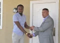 Dellon Caesar receiving the keys to his home from Minister of Housing and Water, Collin Croal