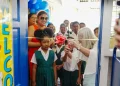 The Honourable Minister of Education, Priya Manickchand, Spread the Words Founder, Ms. Laura Ryan and students engage in the cutting of the ribbon to officially open the new library