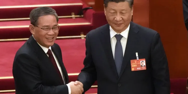 Newly elected Premier Li Qiang, left, shakes hands with Chinese President Xi Jinping during a session of China's National People's Congress (NPC) at the Great Hall of the People in Beijing, Saturday, March 11, 2023. (AP Photo/Mark Schiefelbein)