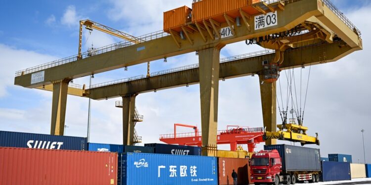 A crane loads containers at the Manzhouli Railway Station in Manzhouli, north China's Inner Mongolia Autonomous Region, March 15, 2023. (Xinhua/Bei He)