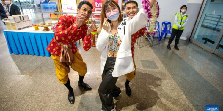 A Chinese tourist takes a selfie with Thai staff members at Don Mueang International Airport in Bangkok, Thailand, Feb 6, 2023. Photo:Xinhua