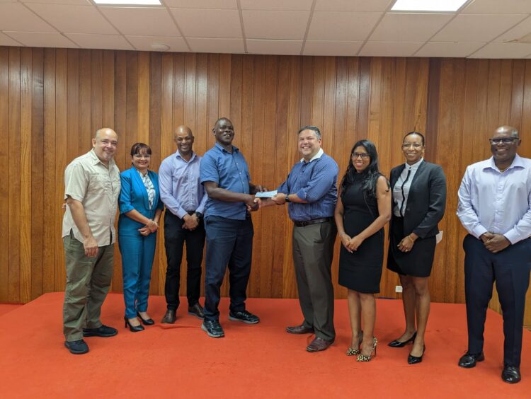 Vice-President Philip Fernandes in centre hands over sponsorship cheque to Mr. Terrence Poole, Technical Director of the Guyana Amateur Boxing Association flanked by Executive Members of the Guyana Olympic Association. From left to right: Mr. Michael Singh, Ms. Emily Ramdhani, Mr. Godfrey Munroe, Mr. Terrence Poole, Mr. Philip Pernandes, Ms. Vidushi Persaud-McKinnon, Ms. Cristy Campbell and Mr. Steve Ninvalle.