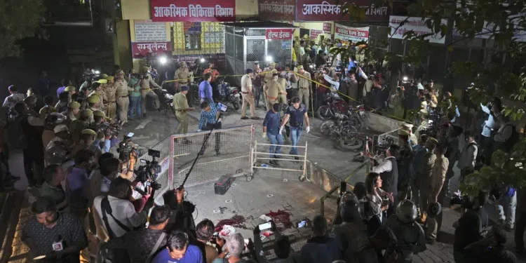 Police and media surround the area where Gangster-turned-politician Atiq Ahmad and his brother Ashraf were shot in front of the Motilal Nehru medical college in, Prayagraj, India, Saturday, April 15, 2023. Jailed gangster-turned-politician Atiq Ahmad and his brother Ashraf were shot dead by unidentified assailants while they were being escorted by police to a medical college here on Saturday night, according to the Indian news agency Press Trust of India. (AP Photo/Rajesh Kumar Singh)