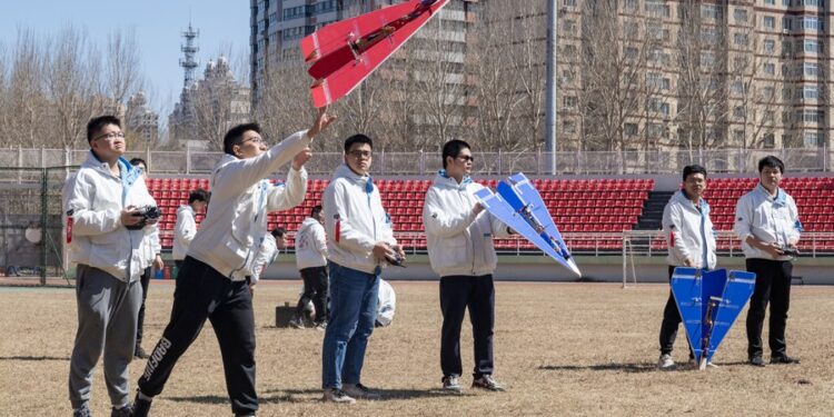 Students from the aviation model association of Harbin Institute of Technology launch a model airplane on campus in Harbin, capital of northeast China's Heilongjiang Province, on April 22 (XINHUA)