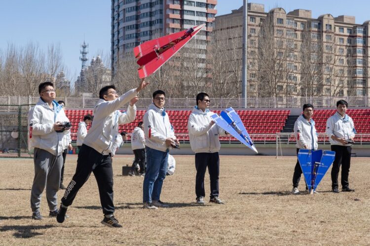 Students from the aviation model association of Harbin Institute of Technology launch a model airplane on campus in Harbin, capital of northeast China's Heilongjiang Province, on April 22 (XINHUA)