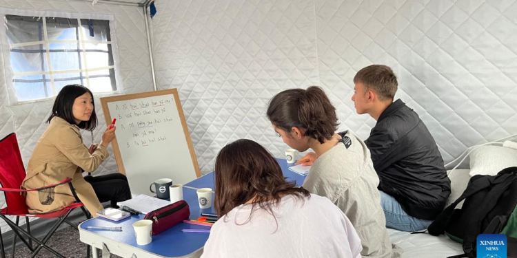 A Chinese volunteer teaches Chinese in the Chinese tent village in Kahramanmaras, Türkiye on May 6, 2023.(Photo by Fang Mingdao/Xinhua)