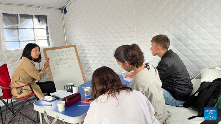 A Chinese volunteer teaches Chinese in the Chinese tent village in Kahramanmaras, Türkiye on May 6, 2023.(Photo by Fang Mingdao/Xinhua)