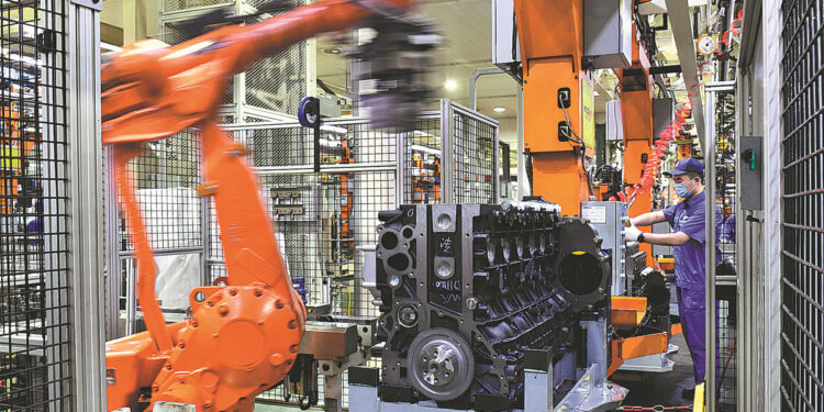An employee works on an assembly line of Weichai Holding Group Co Ltd in Weifang, Shandong province. [Photo/Xinhua]