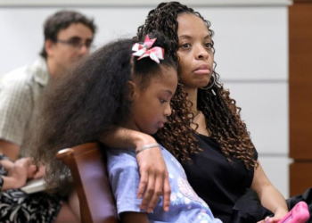 Philana Holmes and her daughter Olivia Caraballo, 7 listen to the final witness in their case at the Broward County Courthouse in Fort Lauderdale on Wednesday, May 10, 2023. McDonald’s and a franchise holder are at fault after a hot Chicken McNugget from a Happy Meal fell on the girl's leg and caused second-degree burns, a jury in South Florida has found, Thursday, May 11. (Mike Stocker/South Florida Sun-Sentinel via AP)