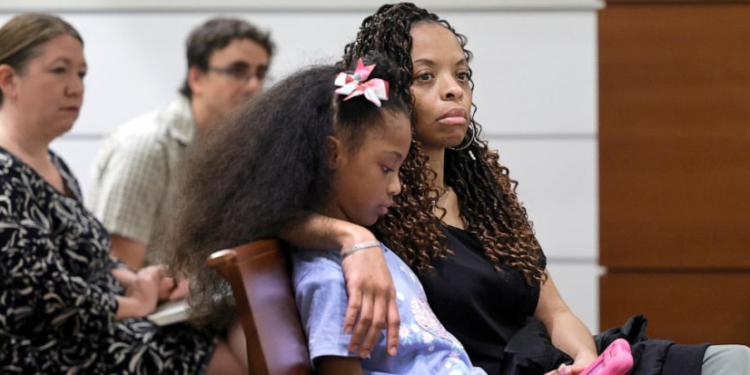 Philana Holmes and her daughter Olivia Caraballo, 7 listen to the final witness in their case at the Broward County Courthouse in Fort Lauderdale on Wednesday, May 10, 2023. McDonald’s and a franchise holder are at fault after a hot Chicken McNugget from a Happy Meal fell on the girl's leg and caused second-degree burns, a jury in South Florida has found, Thursday, May 11. (Mike Stocker/South Florida Sun-Sentinel via AP)