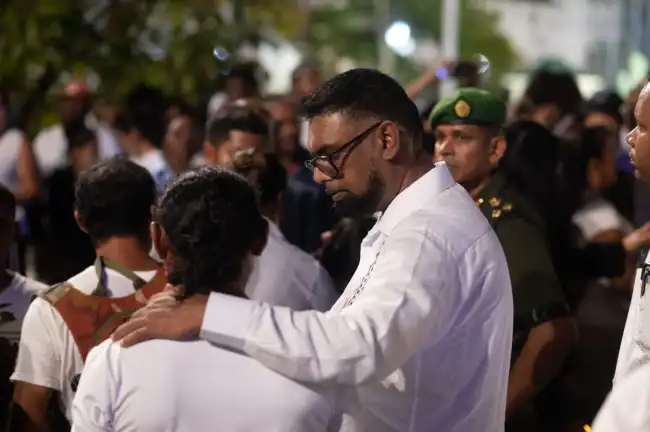 President Irfaan Ali interacting with a grieving family member during the national vigil