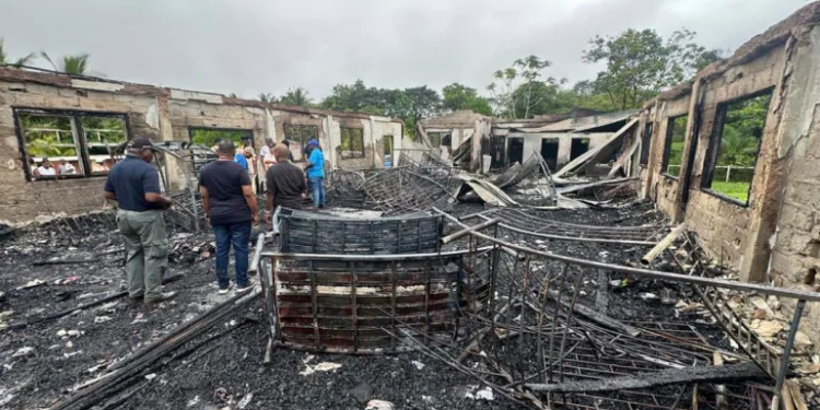 Firefighters had to punch holes through the walls of a dormitory in Mahdia, Guyana, to rescue students trapped inside during a fire [Guyana’s Department of Public Information/AP Photo]