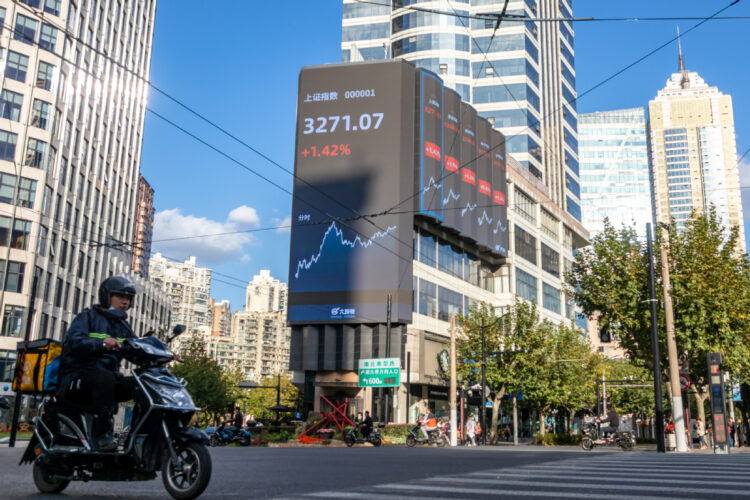 A deliveryman rides past an electronic board in West Nanjing Road in Jing'an district, Shanghai, displaying the trading day's closing levels of key indexes of the Shanghai Stock Exchange and the Shenzhen Stock Exchange on Nov 3. [WANG GANG/FOR CHINA DAILY]