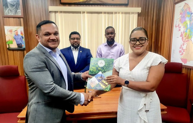 Minister of Natural Resources Hon. Vickram Bharrat M.P., hands over the signed Letter of Approval to SLB’s Managing Director, Ms. Sharlene Seegoolam. They are joined in the background by the Director of the Local Content Secretariat Dr. Martin Pertab and the ministry’s Legal Officer Mr. Michael Munroe
