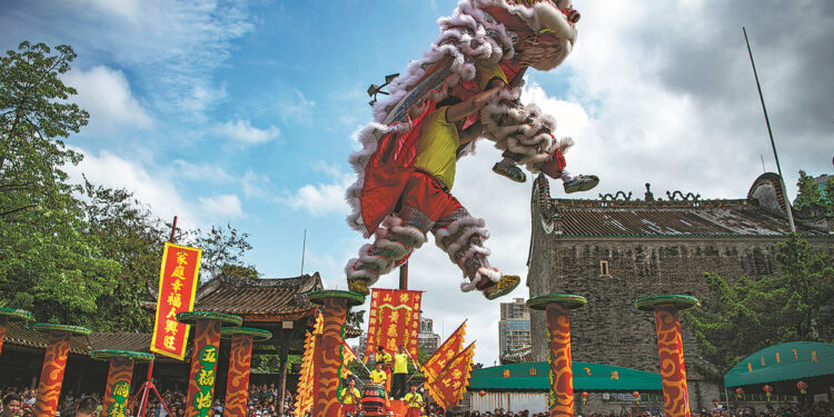 Tourists view a lion dance performance in Foshan, Guangdong province, on Saturday. [PHOTO/CHINA NEWS SERVICE]