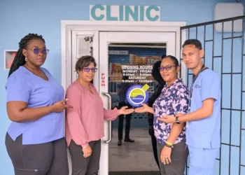 (L-R) Medical Technologist, Debra Blake, Lab. Director Dr. Kamela Bemaul-Sukhu, Head of GNBS Certification Department Andrea Mendonca and Laboratory Quality Manager, Devanad Ramnarine poses with GNBS Certification Sticker at the entrance of the Midway Specialty Care Centre Guyana Laboratory.