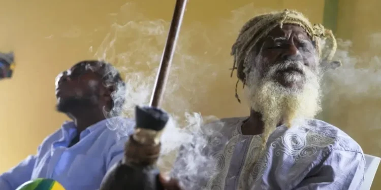 Ras Jah, a member of the Ras Freeman Foundation for the Unification of Rastafari, prepares to pass a chalice pipe with marijuana to the left during service in the tabernacle on Sunday, May 14, 2023, in Liberta, Antigua. The Rastafari faith is rooted in 1930s Jamaica, growing as a response by Black people to white colonial oppression. The beliefs are a melding of Old Testament teachings and a desire to return to Africa. (Photo: Jessie Wardarski/AP)
