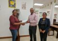 On left, Secretary of the Guyana Rugby Football Union Ms. Petal Adams received sponsorship cheque from President of the Guyana Olympic Association, Mr. Godfrey Munroe in the presence of Secretary-General of the Guyana Olympic Association, Mrs. Vidushi Persaud-McKinnon (on right).