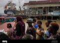 People wait at the Stabroek Market to ferry across the Demerara River, near a container ship in Georgetown, Guyana, on April 12, 2023. Photo: Alamy