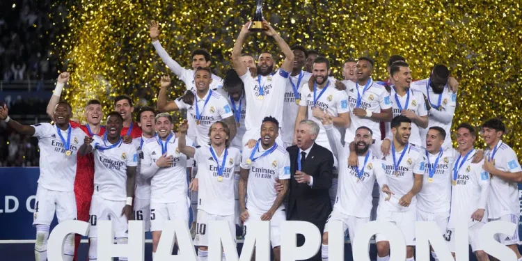 FILE - Real Madrid players celebrate with the trophy after winning the FIFA Club World Cup final match against Al Hilal at Prince Moulay Abdellah stadium in Rabat, Morocco, Saturday, Feb. 11, 2023. The United States will host the Club World Cup in 2025, the first time the FIFA tournament will have 32 teams. Real Madrid, Manchester City and Chelsea already earned places as recent Champions League winners for the expanded tournament lineup that is set to test stadiums and operations one year before the 2026 World Cup. (AP Photo/Manu Fernandez, File)