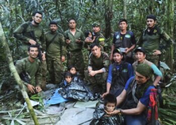 In this photo released by Colombia's Armed Forces Press Office, soldiers and Indigenous men pose for a photo with the four Indigenous brothers who were missing after a deadly plane crash, in the Solano jungle, Caqueta state, Colombia, Friday, June 9, 2023. Colombian President Gustavo Petro said Friday that authorities found alive the four children who survived a small plane crash 40 days ago and had been the subject of an intense search in the Amazon jungle. (Colombia's Armed Force Press Office via AP)