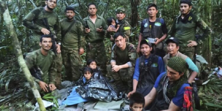 In this photo released by Colombia's Armed Forces Press Office, soldiers and Indigenous men pose for a photo with the four Indigenous brothers who were missing after a deadly plane crash, in the Solano jungle, Caqueta state, Colombia, Friday, June 9, 2023. Colombian President Gustavo Petro said Friday that authorities found alive the four children who survived a small plane crash 40 days ago and had been the subject of an intense search in the Amazon jungle. (Colombia's Armed Force Press Office via AP)
