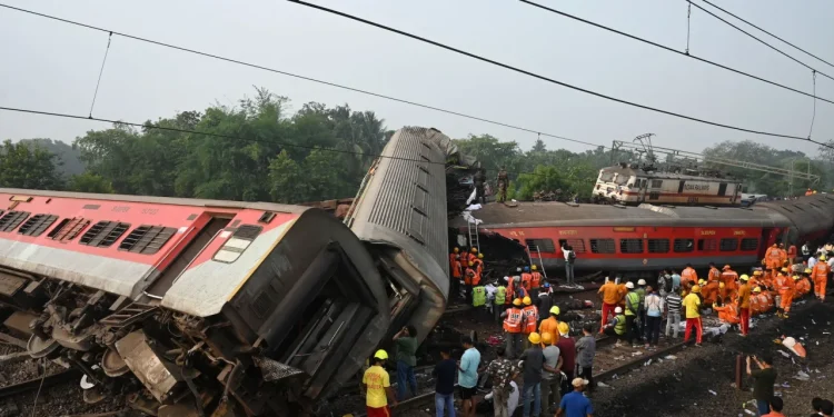 Rescue workers gather around damaged carriages during search for survivors at the accident site on Saturday. Dibyangshu Sarkar/AFP/Getty Images