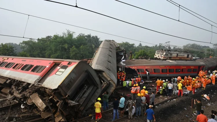 Rescue workers gather around damaged carriages during search for survivors at the accident site on Saturday. Dibyangshu Sarkar/AFP/Getty Images