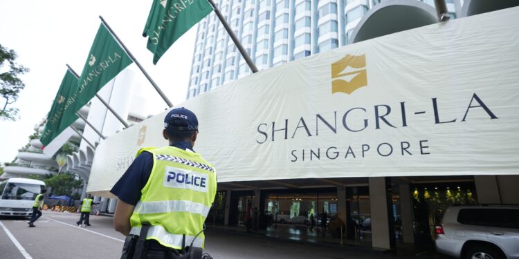Police officers guard near the entrance of the Shangri-La Hotel, the venue for the 20th International Institute for Strategic Studies (IISS) Shangri-La Dialogue, Asia's annual defense and security forum, in Singapore, Friday, June 2, 2023. (AP Photo/Vincent Thian)
