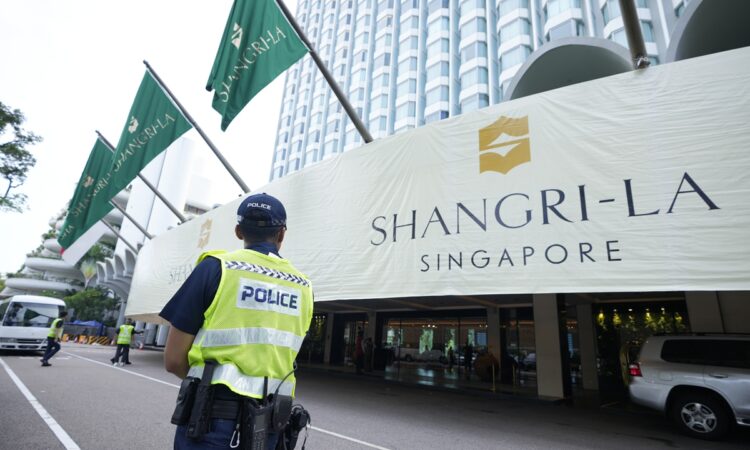 Police officers guard near the entrance of the Shangri-La Hotel, the venue for the 20th International Institute for Strategic Studies (IISS) Shangri-La Dialogue, Asia's annual defense and security forum, in Singapore, Friday, June 2, 2023. (AP Photo/Vincent Thian)