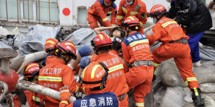 Rescuers pull out a trapped person after the roof of a gymnasium at a school in Qiqihar, Heilongjiang province, collapsed on July 23, 2023. [Photo/Weibo account of People's Daily]
