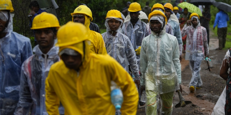 Rescuers walk towards the site of a landslide in Raigad district, western Maharashtra state, India, Thursday, July 20, 2023. While some people are reported dead many others feared trapped under piles of debris. (AP Photo/Rafiq Maqbool)